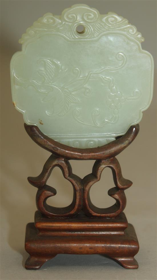 A Chinese pale celadon jade plaque, 19th century, 5.9cm, wood stand